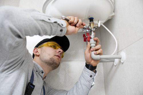 worker repairing water heater 